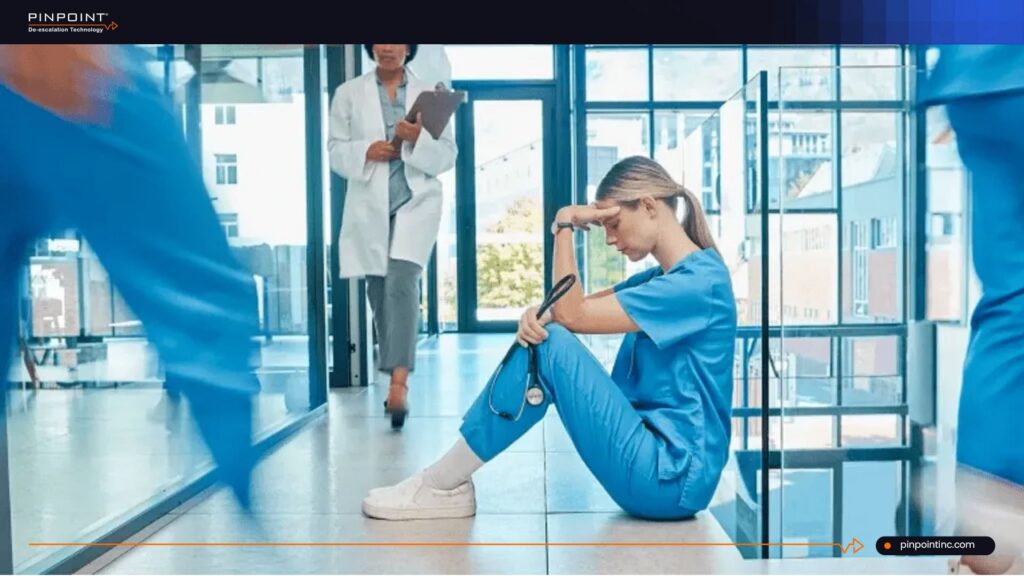 Stressed nurse sitting in hospital hallway highlighting the need for a non-tracking safety system