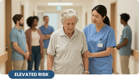 An Asian nurse assisting an elderly woman walking down a clinic hallway with a blue graphic label on the bottom corner indicating an elevated risk environment.