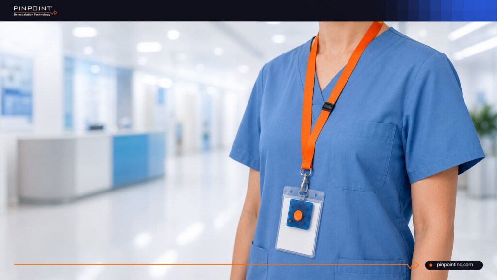 Pinpoint guide on duress alert solutions for healthcare showing a caregiver wearing a badge-style alert device in a hospital hallway.