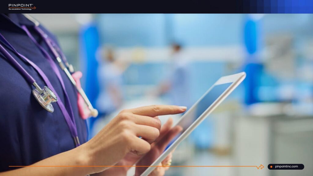 Pinpoint guide on workplace duress RTLS showing a healthcare worker using a tablet, introducing five drawbacks of RTLS and a non-tracking staff safety alternative.